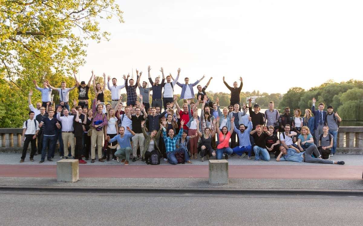 Gruppenfoto von Walk & Talk Hamburg im Park an der Alster, viele Teilnehmende jubeln mit erhobenen Armen